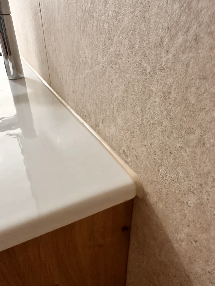 Weisses Lavabo mit Anschluss an eine beige Wand