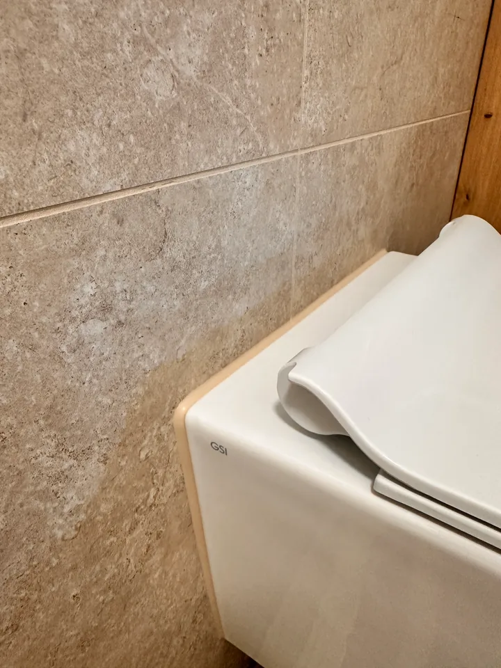 Hänge-WC am Übergang zur beigen Wandverkleidung