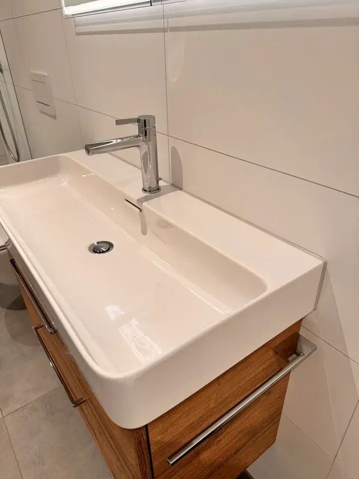 Rechteckiges Lavabo vor weissen Wandplatten