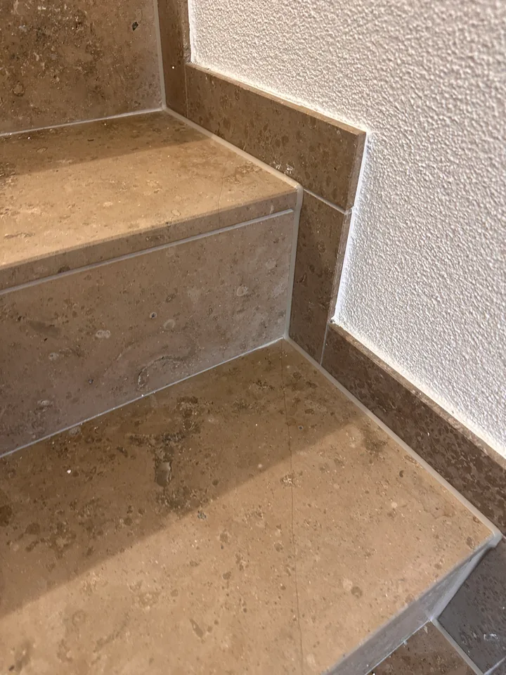 Dieselben Steinstufen mit Sockel an der weissen Wand, die Kanten zwischen Stufe und Sockel zeigen jetzt helle Linien